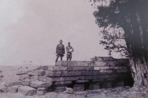 black and white photo of two men standing on the Khmer bridge