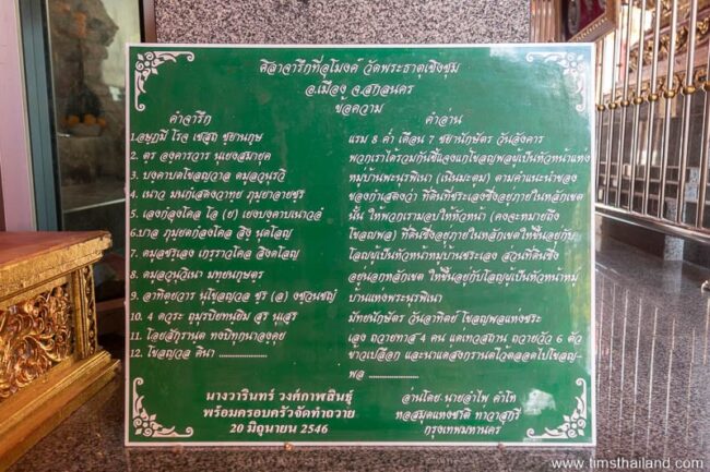 green sign with a Thai translation of the inscription