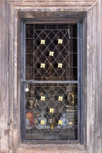 gated entrance with Buddhas behind it