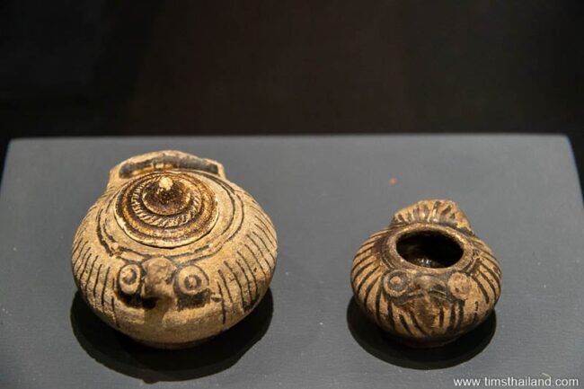 deux petits pots avec des lignes peintes dessus