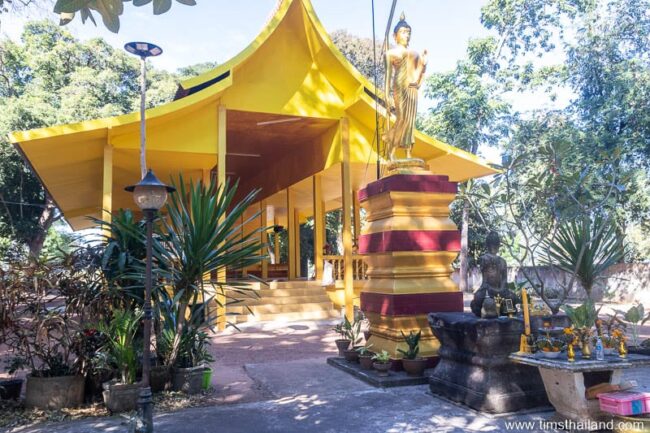 Khmer pedestal and Buddha statue in front of wihan building