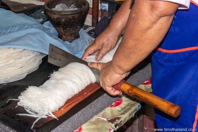 woman cutting phimai noodles