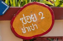 <b>Ban Tha Pa Pao, Lamphun province</b><br>There's no story or symbolism, I just like that it's made from a slice of tree trunk. street sign made of wood and painted orange and red