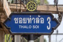 <b>Tha Lo, Kanchanaburi province</b><br>The wheel is part of the symbol for the Army Transportation Department Training Center located here. Kanchanaburi street sign with wheel on top