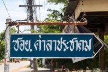 <b>Ban Wang Nam Khao, Nong Bua Lamphu province</b><br>As far as I can determine, this naga is just some low-cost decorative flair and doesn’t represent anything specific to the village. street sign with naga on top