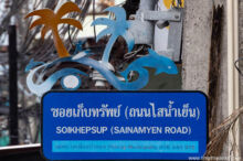 <b>Patong, Phuket province</b><br>Patong is a seaside resort town. dolphin, surfer, and palm trees on top of a street sign