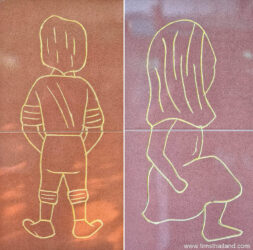 thai bathroom sign with man standing and woman sitting